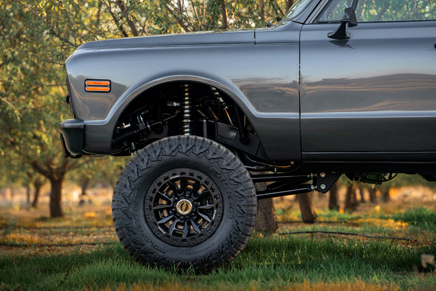 Front quarter panel of PPC Blazer parked in a field with trees in the background